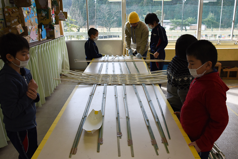 紙で作った模型で構造を確認しながら竹を編み始める。